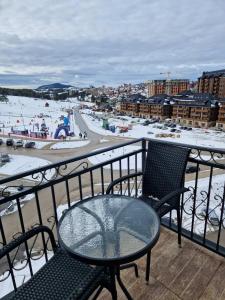 a table and chairs on a balcony with a beach at Gondola Neda Lux in Zlatibor