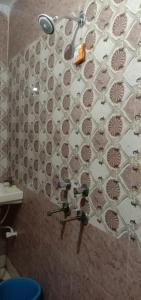 y baño con ducha y pared de azulejos. en Hotel A Star & Restaurant By WB Inn en Ghaziabad