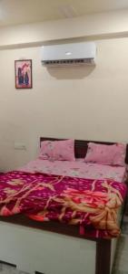 a bedroom with a bed with a pink comforter at Hotel A Star & Restaurant By WB Inn in Ghaziabad