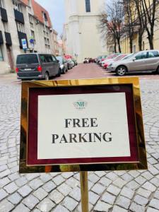 a sign that says free parking on a street at NARUTIS hotel in Vilnius