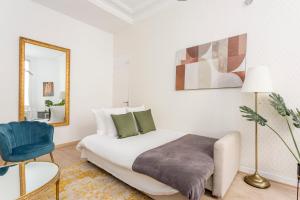 um quarto com uma cama, um espelho e uma cadeira em Cosy 2 bedrooms 1 bathroom apartment - Monceau em Paris