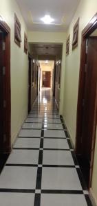 a hallway with black and white tiled floors in a building at Hotel A Star & Restaurant By WB Inn in Ghaziabad