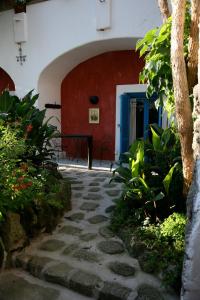 einen Steingang in einem Innenhof mit einer roten Wand in der Unterkunft Dimora Coloniale B&B in Ischia