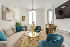 uma sala de estar com um sofá, cadeiras e uma mesa em Cosy 2 bedrooms 1 bathroom apartment - Monceau em Paris