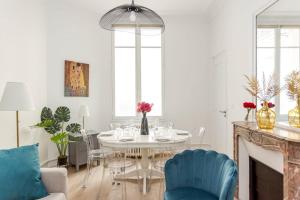 uma sala de jantar com uma mesa branca e cadeiras azuis em Cosy 2 bedrooms 1 bathroom apartment - Monceau em Paris