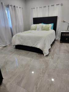 a bedroom with a bed with a marble floor at The Hide Away in Nassau