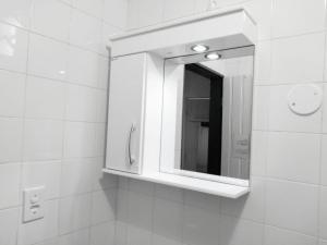 a bathroom with a medicine cabinet and a mirror at Suítes a 50 metros da Rua das Pedras in Búzios