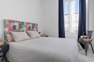 a bedroom with a large bed with a large window at AlohaMundi Adriano in Seville