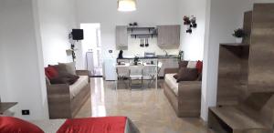 a living room with two couches and a kitchen at SHORT LETS Radici di Puglia in Fragagnano