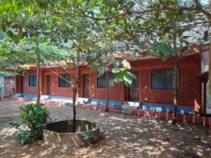 a house with two trees in front of it at Palm Beach Resort in Kumta