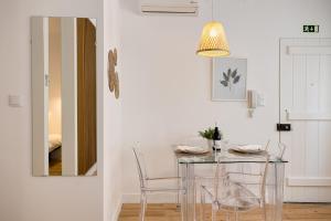 a dining room with a glass table and chairs at Alfama Chic Penabuquel3 in Lisbon