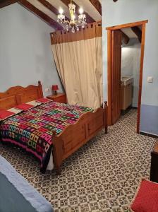 1 dormitorio con cama de madera en una habitación en Acogedora casa de pueblo, con todas las comodidades, en Moratalla