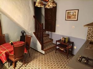 Habitación con escalera, mesa y sillas en Acogedora casa de pueblo, con todas las comodidades, en Moratalla