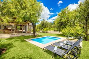 a backyard with a swimming pool and lawn chairs at Makanyane Lodge in Matlhagame