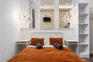 1 dormitorio con 1 cama con 2 mesas y 2 espejos en VP12 Apartments, en Budapest