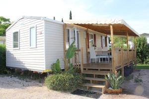 a tiny house with a porch and a deck at Mobil-Home 2 chambres camping 4 étoiles in Fréjus