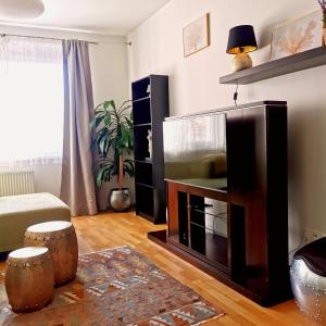 a living room with a flat screen tv and a couch at CozyHome Retro Apartment in Bratislava