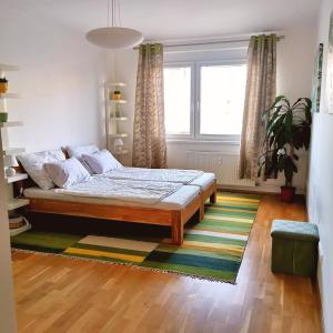 a bedroom with a bed and a large window at CozyHome Retro Apartment in Bratislava