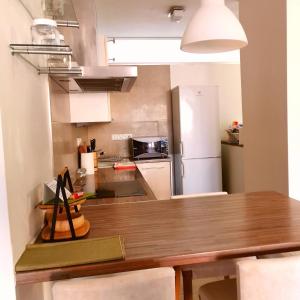 a kitchen with a wooden table and a refrigerator at CozyHome Retro Apartment in Bratislava