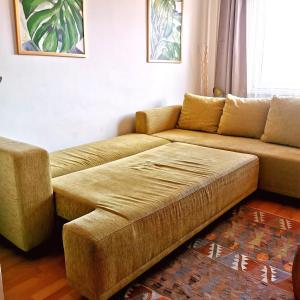 ein Wohnzimmer mit einem Sofa und einem Stuhl in der Unterkunft CozyHome Retro Apartment in Bratislava