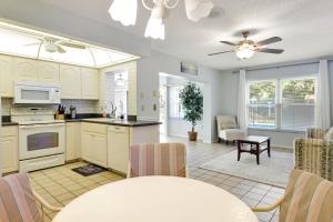 a kitchen and living room with a table and a ceiling fan at Village Green Oasis in Bradenton