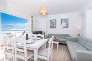 a living room with a table and a couch at On The Beach Voramar by Sealand Villas in Port de Pollensa