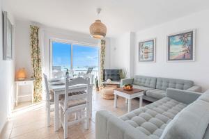 a living room with a couch and a table at On The Beach Voramar by Sealand Villas in Port de Pollensa