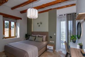 a bedroom with a large bed and a chandelier at Stone villa Halepa with panoramic view. in Néon Khoríon