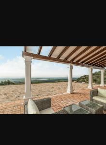 - un pavillon avec un canapé et une table sur une terrasse dans l'établissement Casa Rural Alberquillas, à La Puebla de los Infantes