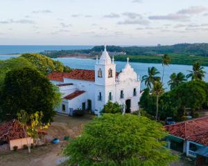 Une église insulaire avec l'océan en arrière-plan dans l'établissement Villa Velha Flats, à Itamaracá