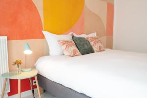 two beds in a room with a colorful wall at Superbe appartement avenue de Champagne + parking in Épernay