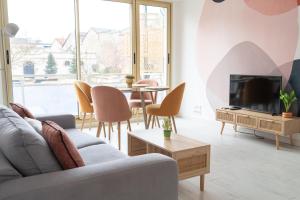 a living room with a couch and a tv and a table at Superbe appartement avenue de Champagne + parking in Épernay