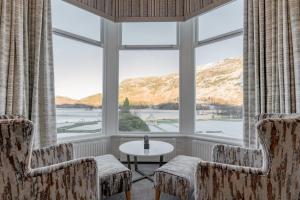 Habitación con ventana grande con sillas y mesa. en The Inn On The Lake en Glenridding