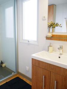 a bathroom with a sink and a window and a mirror at Mobil-Home 2 chambres camping 4 étoiles in Fréjus