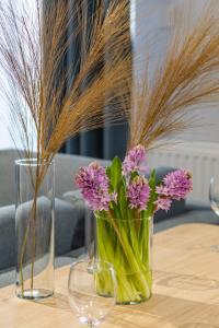 dos jarrones con flores en una mesa en Baltic Marina Residence Sauna & Fitness Apartments by Renters en Kołobrzeg