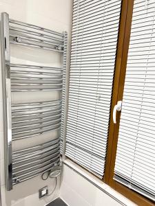 a bathroom with a toilet and a window with blinds at Eden Moon in Paris