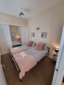 a bedroom with two beds with pink pillows at City Centre Flat, Harbour View in Inverness