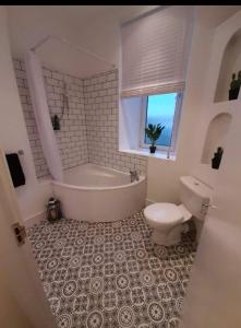 a bathroom with a tub and a toilet and a sink at City Centre Flat, Harbour View in Inverness +6 photos