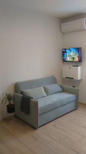 a couch in a living room with a tv at White brick Apartment in Zagreb
