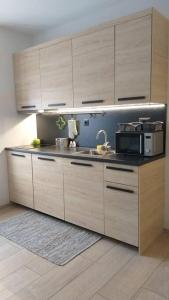 a kitchen with wooden cabinets and a microwave at White brick Apartment in Zagreb