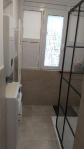 a bathroom with a window and a sink and a toilet at White brick Apartment in Zagreb