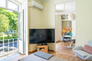un soggiorno con una grande TV a schermo piatto di Casa St Yves - Sunny flat in Setúbal on Av Luisa Todi a Setúbal