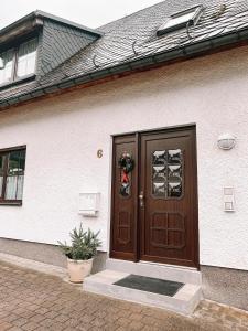 une maison dotée d'une porte en bois avec une couronne sur celle-ci dans l'établissement Ferienwohnung zum Schreckenberg, à Annaberg-Buchholz