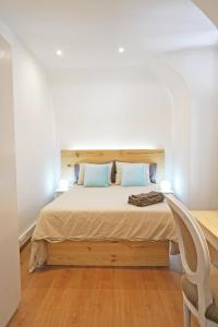 1 dormitorio con 1 cama con 2 lámparas y 1 silla en Casa St Yves - Sunny flat in Setúbal on Av Luisa Todi, en Setúbal