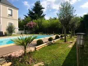 een zwembad in een tuin naast een huis bij Villa de 6 chambres avec piscine privee jardin clos et wifi a Saint Cyr sur Loire in Saint-Cyr-sur-Loire