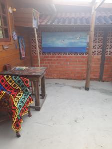 Zimmer mit einem Holztisch mit einer Decke in der Unterkunft Morada da Hortensia in Guarda do Embaú