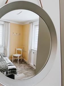 a mirror in a bedroom with a bed and a chair at Ferienwohnung zum Schreckenberg in Annaberg-Buchholz