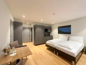 um quarto com uma cama, uma secretária e uma mesa em Aparthotel Beinwil am See em Beinwil