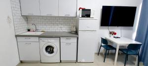 a small kitchen with a washing machine and a table at Hotel Apartment Colony Beach Tel Aviv Bat Yam 9 in Bat Yam
