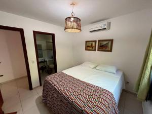 een slaapkamer met een bed en een hanglamp bij Casa na Praia da Pipa próximo a Praia do Amor - RN in Pipa